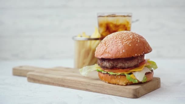 Čerstvý chutný burger podávaný se sodou a hranolky na bílém stole — Stock video