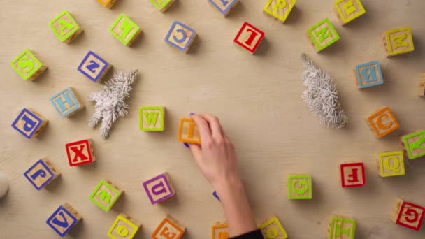 Femme main arrangeant des cubes en bois avec mot WINTER vue de dessus — Video