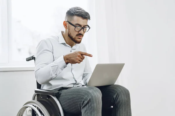 Empresario sentado en silla de ruedas y usando laptop — Foto de Stock