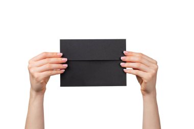 Manikürlü kadın eli beyaz üzerinde izole edilmiş bir zarf tutuyor.