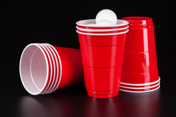 Tazas de plástico rojo y pelota para el juego de pong de cerveza — Foto de Stock