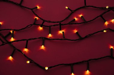 Parlak pembe arka planda aydınlatılmış çelenk ışıkları