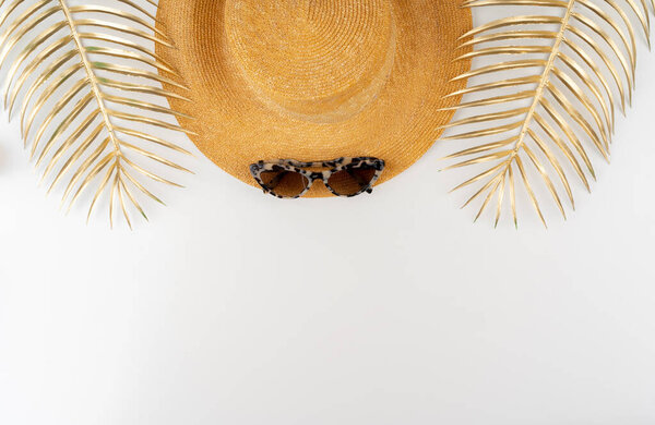 Соломенная шляпа и солнечные очки вид сверху на белом фоне