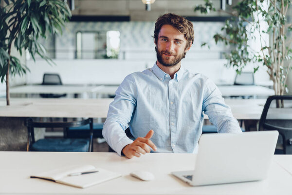 Businessman in shirt working on his laptop in an office