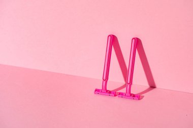 Pembe arka planda tek kullanımlık jiletler, kopyalama alanı