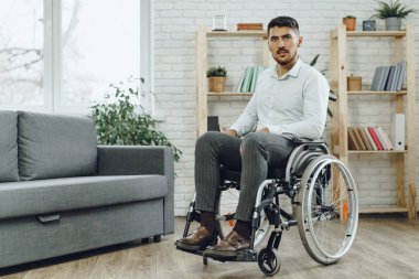 Resmi olarak tekerlekli sandalyede oturan engelli bir adamın portresi.