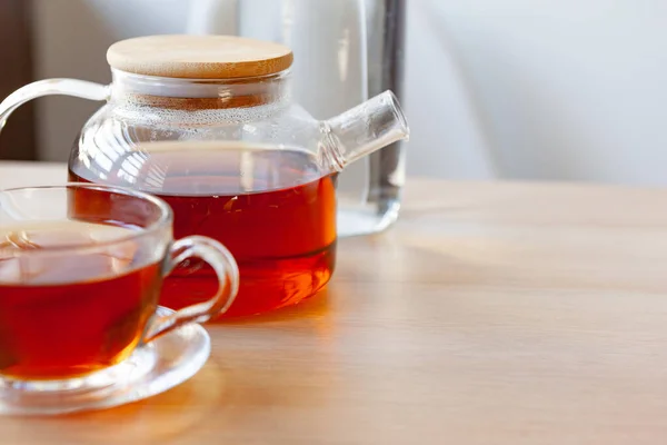 Teekanne aus Glas mit schwarzem Tee auf Holztisch — Stockfoto
