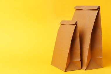 Parlak sarı kağıt arkaplanındaki el işleri paketleri