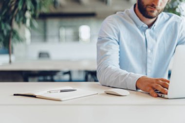 Ofiste dizüstü bilgisayarıyla çalışan iş adamı.