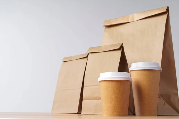 Sacos de papel com levar comida e copos de café recipientes — Fotografia de Stock