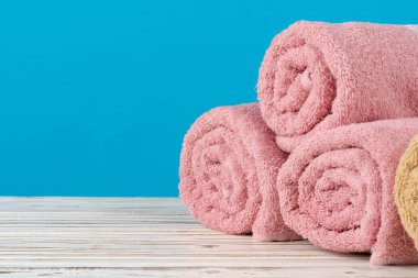 Tahta bir masada rulo havlu yığını.