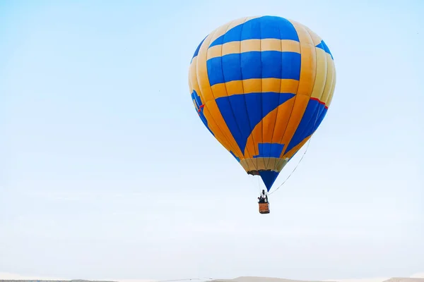 Veelkleurige luchtballon in heldere blauwe lucht — Stockfoto