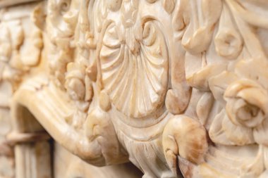 Taş lüks şöminenin üzerine oyulmuş desenler. Yakın çekim.