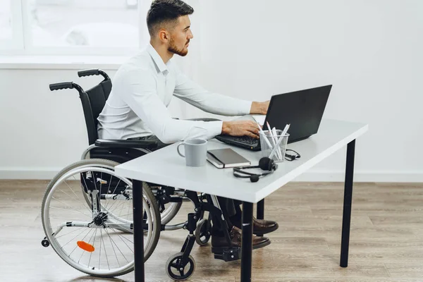 Hombre discapacitado en silla de ruedas usando laptop — Foto de Stock