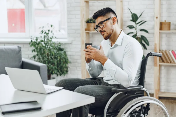 職場で働く車椅子の障害者の青年 — ストック写真