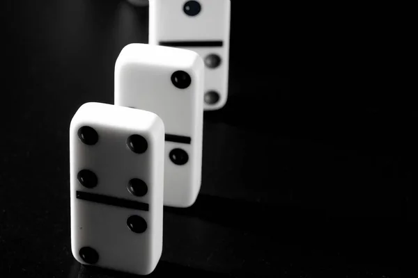 Domino pieces put in a row on black background — Stock Photo, Image