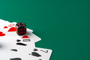 Zarlar ve kartlar masaya saçılmış.