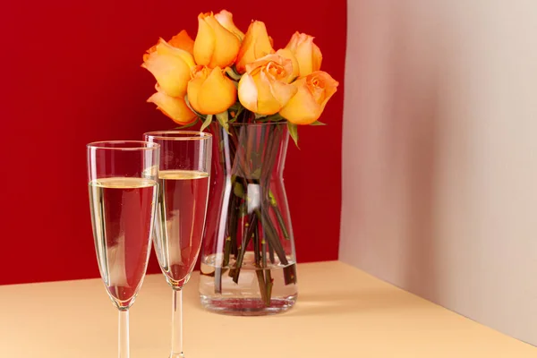 Zavřít fotografii sklenice šampaňského s růžemi ve váze — Stock fotografie