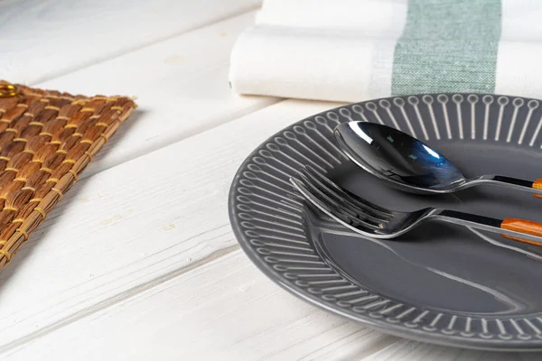 Glänsande grå keramik platta med bestick på träbord — Stockfoto