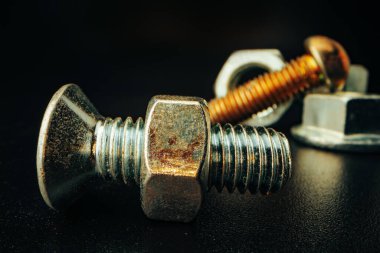 Siyah arka planda metal vidalar ve fındıklar