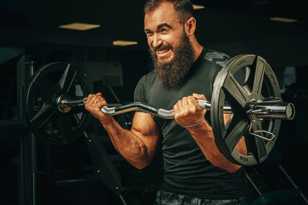 Powerlifter erős karok emelő súlyzó egy edzőteremben — Stock Fotó