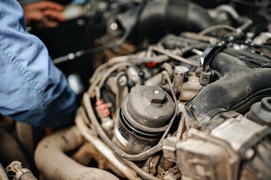 Otomobil tamircisi arabanın motorunu kontrol ediyor.