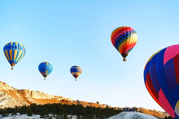 Büyük beyaz dağların yakınında açık gökyüzünde uçan renkli hava balonları — Stok fotoğraf