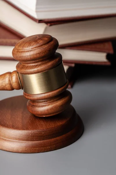 Brown wooden gavel with stack of books on gray table — Stock Photo, Image