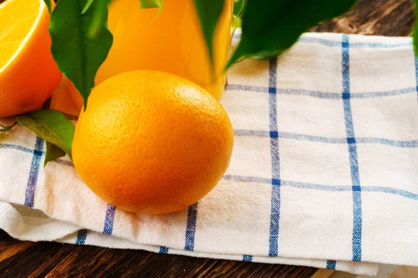 나무 식탁에 냅킨을 얹은 오렌지 주스 병의 뚜껑을 닫은 모습 — 스톡 사진