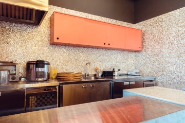 Pembe ahşap rafı ve aletleri olan modern mutfak.