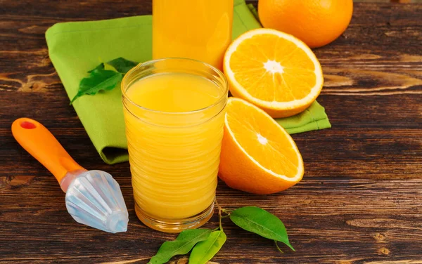 Copo de suco de laranja na mesa de madeira de perto — Fotografia de Stock