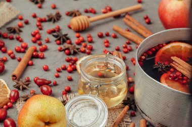 Gri masadaki baharat ve böğürtlenli sıcak şarap bardağını kapat.