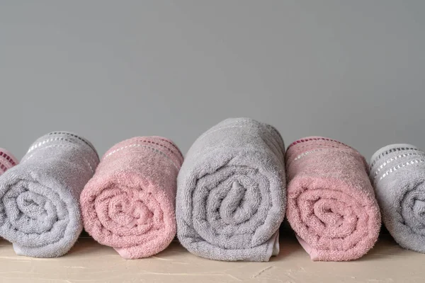 Pilha de toalhas novas limpas contra a parede cinza — Fotografia de Stock