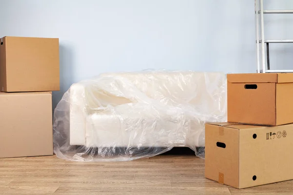 箱に詰められた家庭用品と移動するためのパックソファ — ストック写真