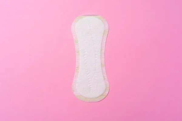 Almohadilla higiénica femenina sobre fondo rosa vista superior —  Fotos de Stock
