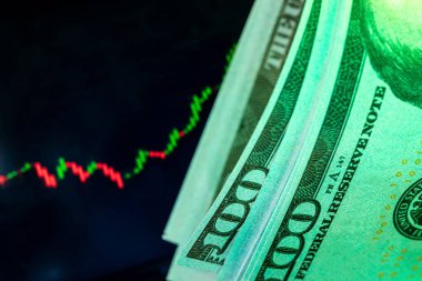 Fiyat tablosu olan bir monitörün önünde dolar. Eski ve ticaret.