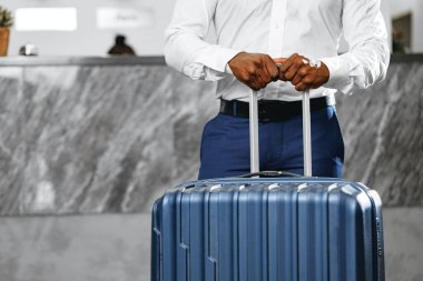 Otel lobisinde bavuluyla tanınmayan bir işadamı duruyor.