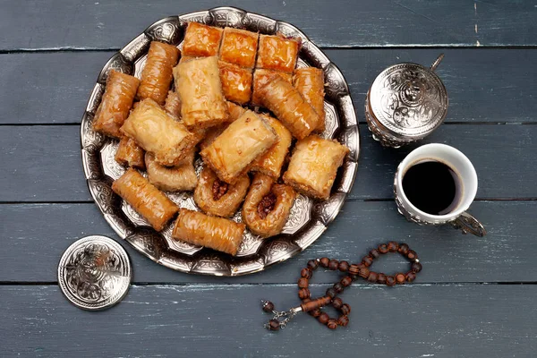 Bovenaanzicht van grote metalen dienblad met turkse baklava op planken houten tafel Stockfoto