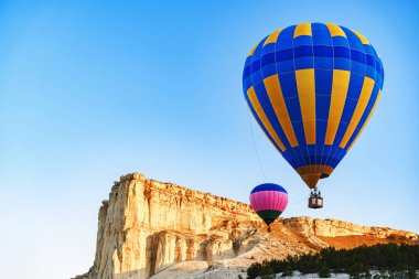 Büyük beyaz dağların yakınında açık gökyüzünde uçan renkli hava balonları