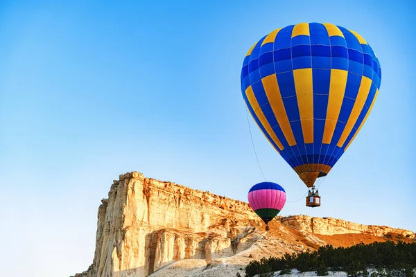 Büyük beyaz dağların yakınında açık gökyüzünde uçan renkli hava balonları — Stok fotoğraf