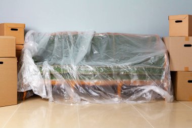 Ev eşyalarını kutulara koyup taşınmak için kanepeye tıkıştırdım.