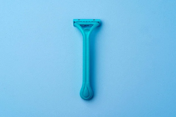 Pojedyncza jednorazowa brzytwa dla kobiet na niebieskim tle — Zdjęcie stockowe