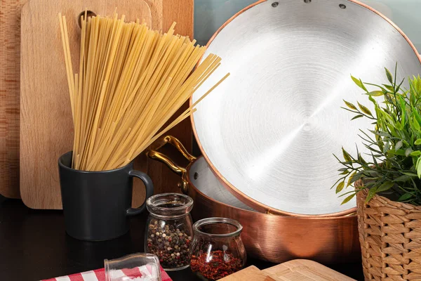 Сухие спагетти на кухонном столе с кухонной утварью — стоковое фото