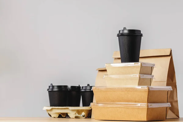 Muitos vários recipientes de comida take-out, caixa de pizza, xícaras de café e sacos de papel no fundo cinza claro — Fotografia de Stock
