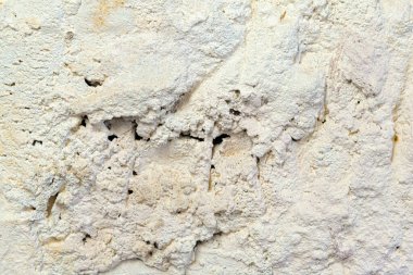Arka planda çatlaklar olan pürüzlü eski beyaz bir duvar.