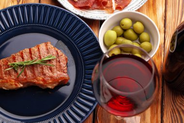 Mavi tabakta servis edilen ızgara biftek.