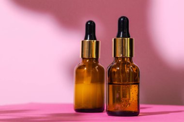 Parlak pembe arka planda cilt ürünleri kapları