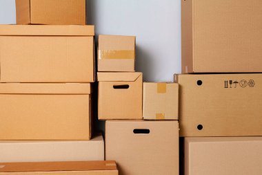 Gri duvara karşı yerde hareket etmek için karton kutular