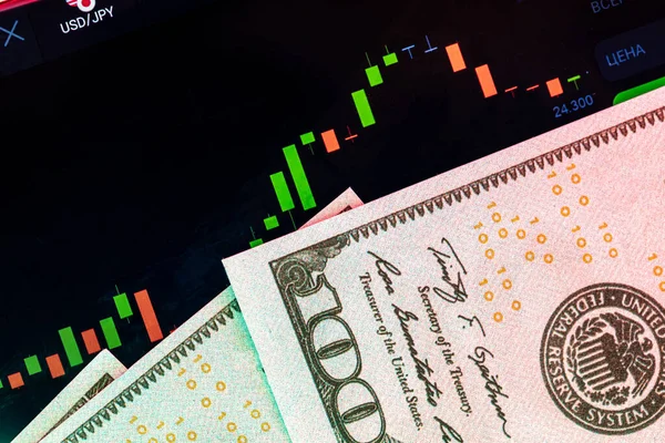 Dollari davanti a un monitor con un grafico dei prezzi. Forex e trading. — Foto Stock