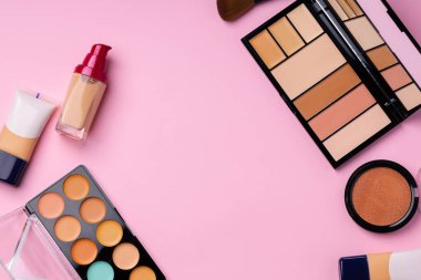 Pembe arka planda yüz rengi için kozmetik ürünler